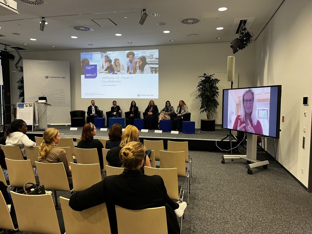 Das Foto zeigt einen Blick aus dem Zuschauerraum auf das Podium bei der Diskussion zu Frauen in MINT.